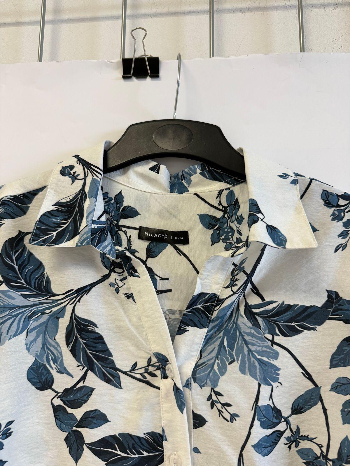 a white shirt with blue leaves on it