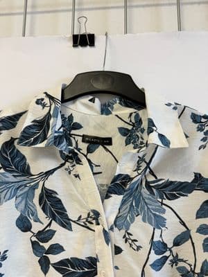 a white shirt with blue leaves on it