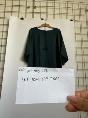 a person holding a piece of paper with a shirt on it