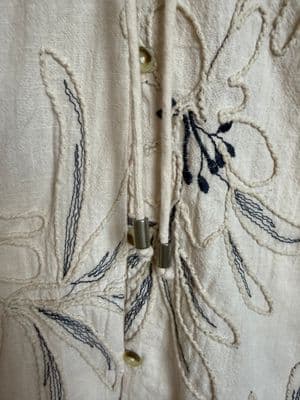 a close up of a white shirt with a flower design on it