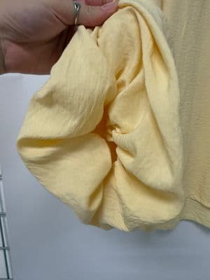 a person holding a yellow cloth in their hand