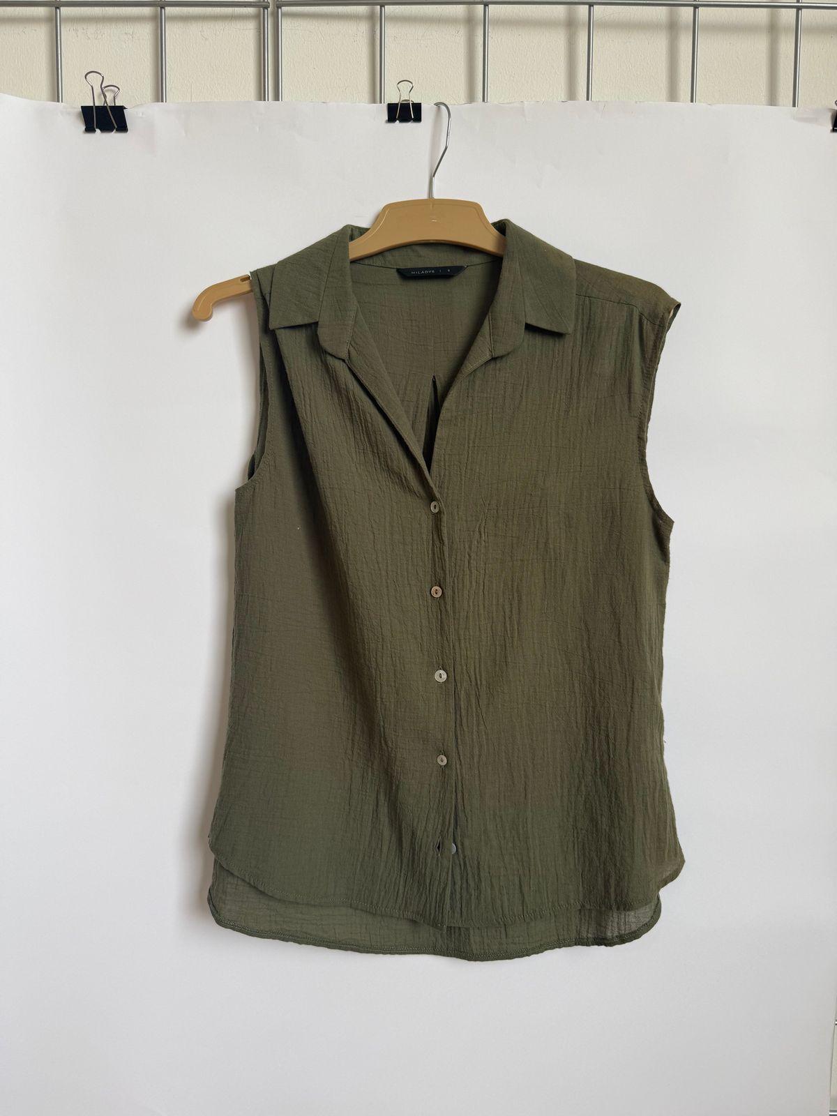 a green shirt hanging on a white wall