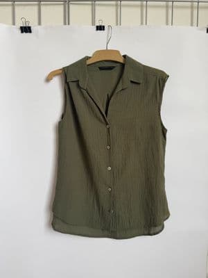 a green shirt hanging on a white wall