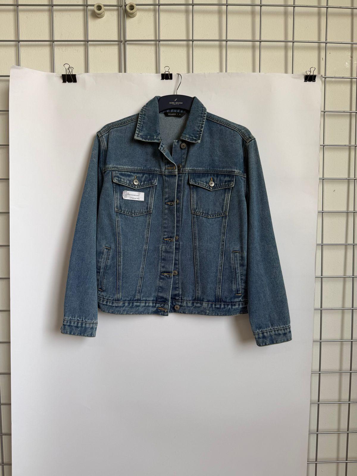 a blue jean jacket hanging on a wall