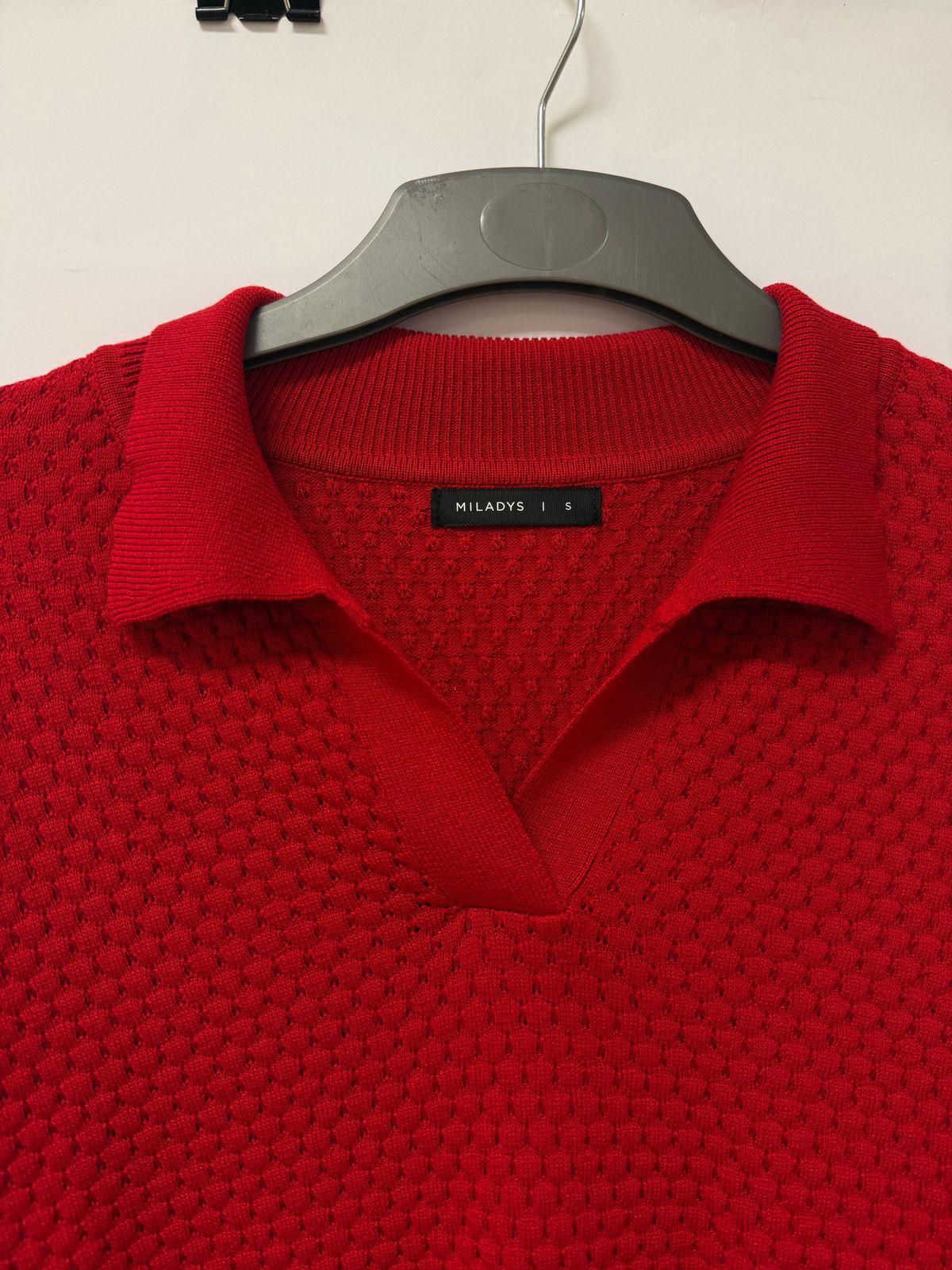 a red polo shirt hanging on a hanger