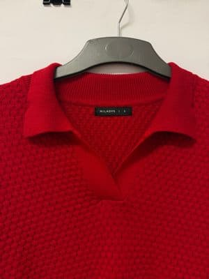 a red polo shirt hanging on a hanger
