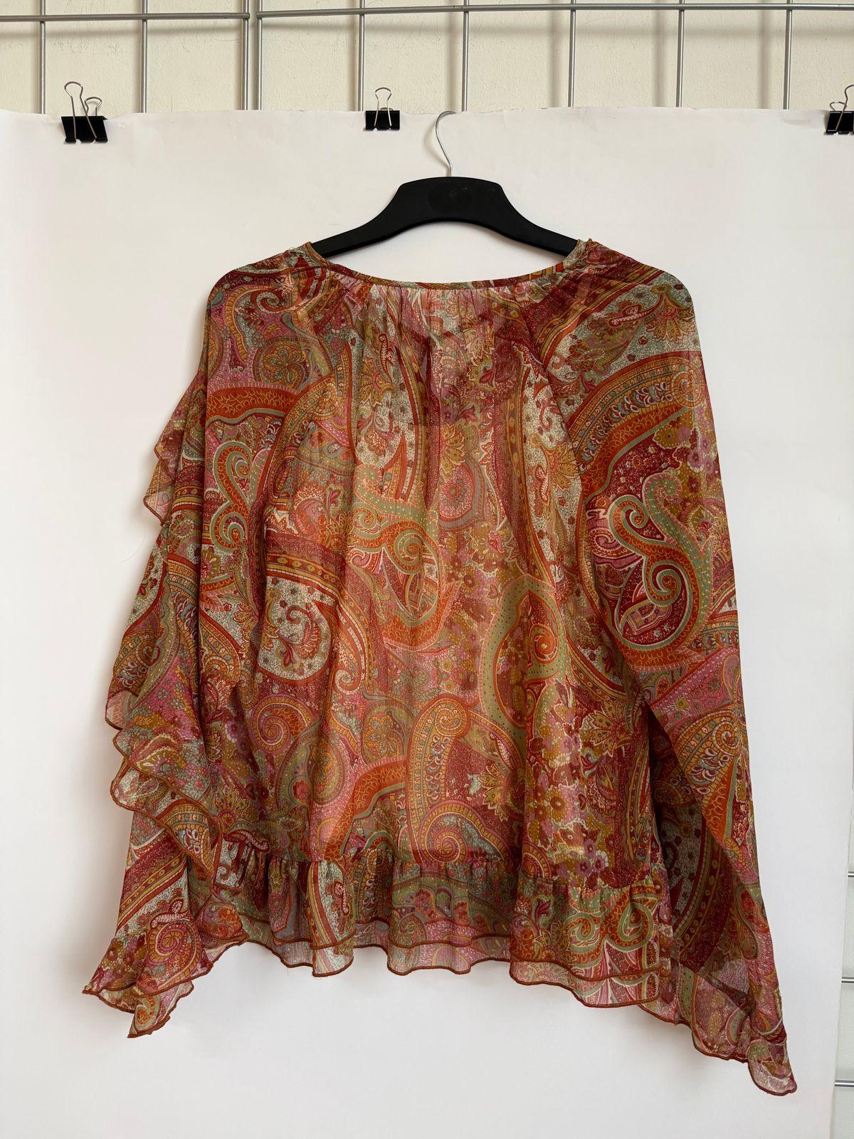 a blouse hanging up on a hanger