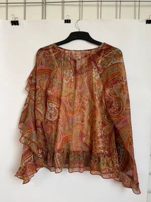 a blouse hanging up on a hanger