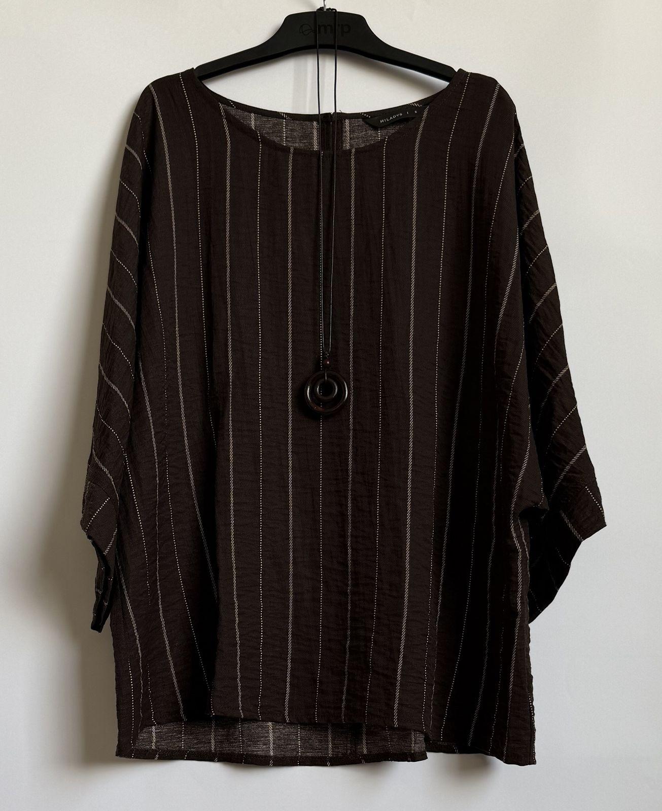 a shirt hanging on a hanger on a wall