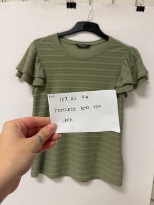 a person holding a piece of paper in front of a t - shirt