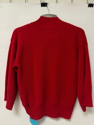 a red sweater hanging on a white wall