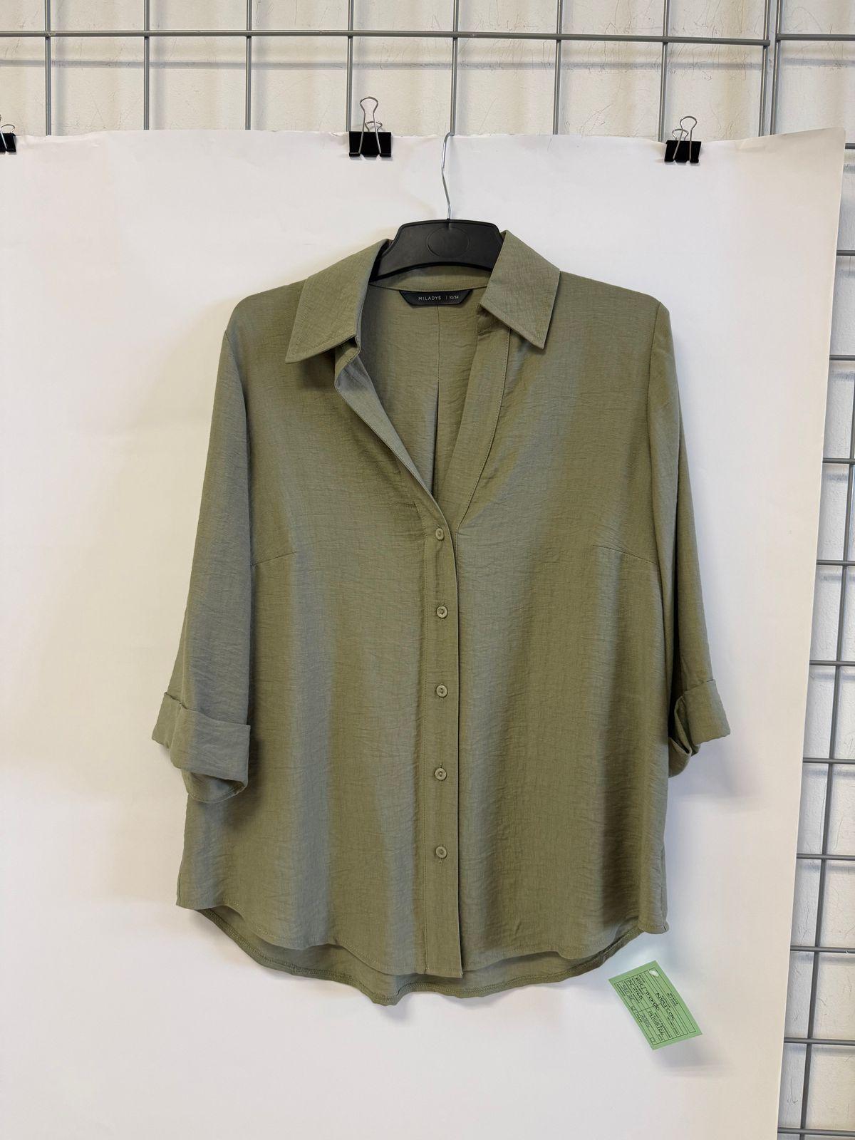 a green shirt hanging on a white wall