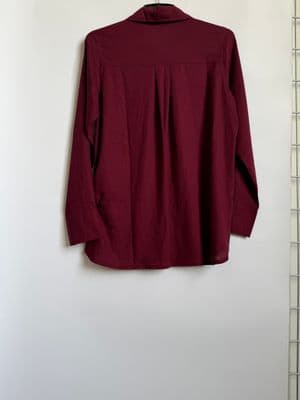 a red shirt hanging on a white wall