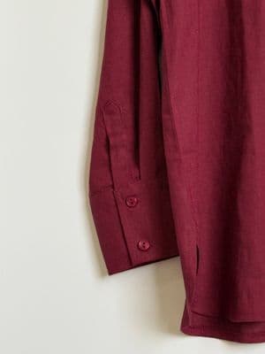 a red shirt hanging on a white wall
