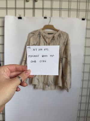 a person holding a piece of paper with a picture of a shirt on it