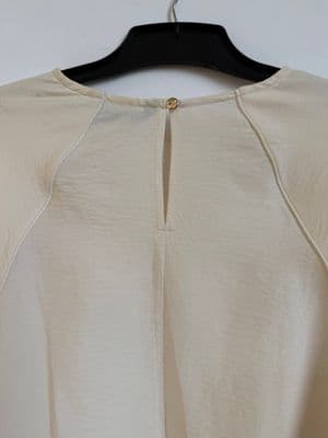a white shirt hanging on a black hanger