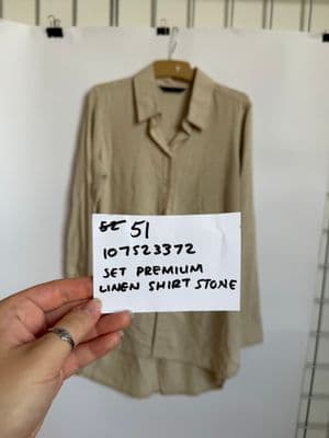 a person holding a piece of paper with a shirt on it