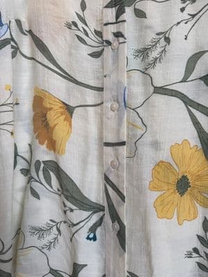 a white shirt with yellow and blue flowers on it
