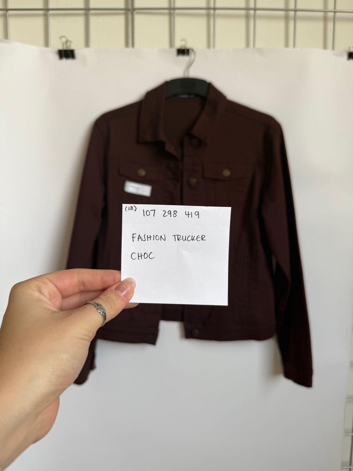 a person holding a piece of paper in front of a jacket