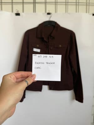 a person holding a piece of paper in front of a jacket