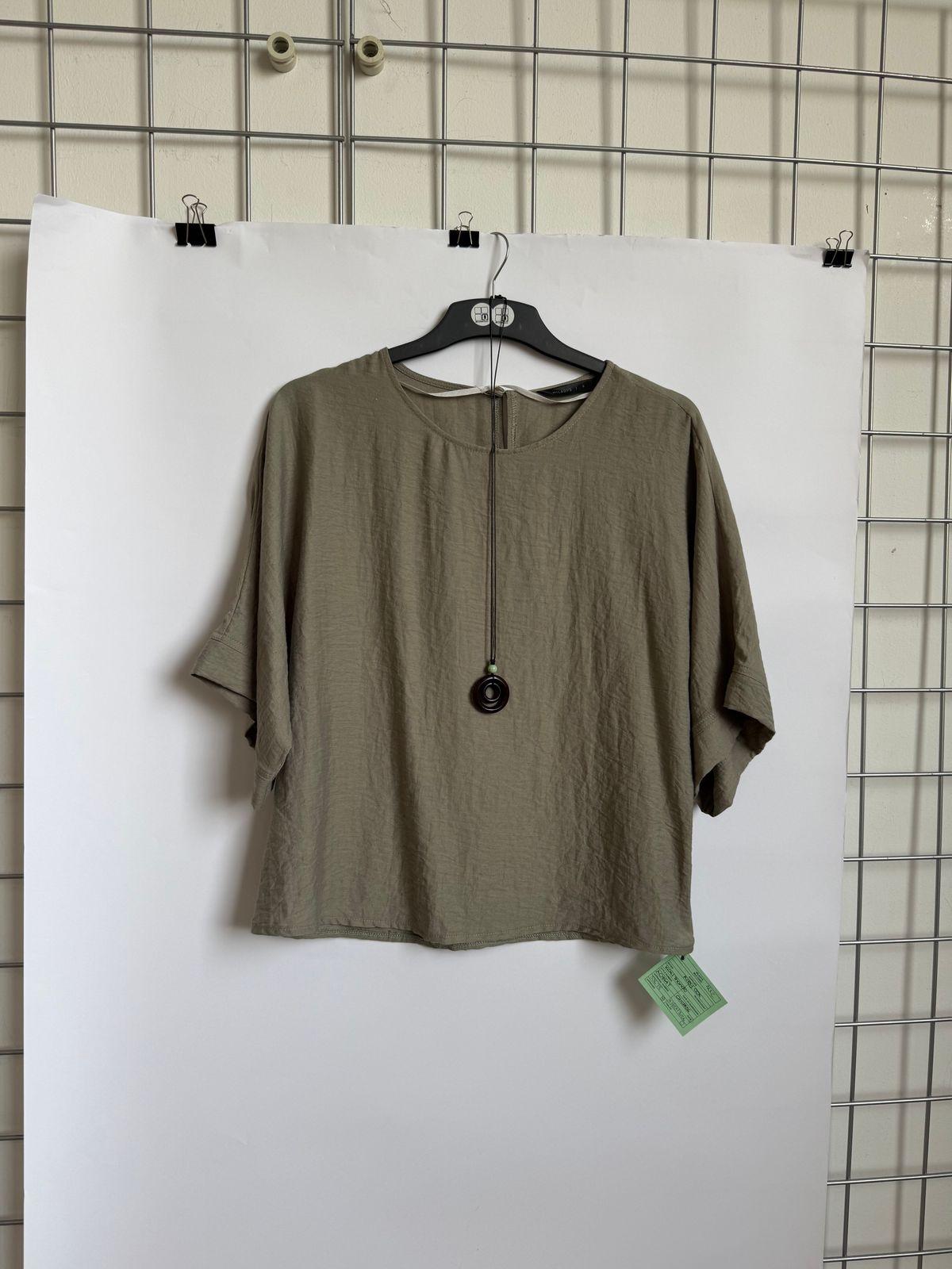 a t - shirt hanging on a hanger on a wall