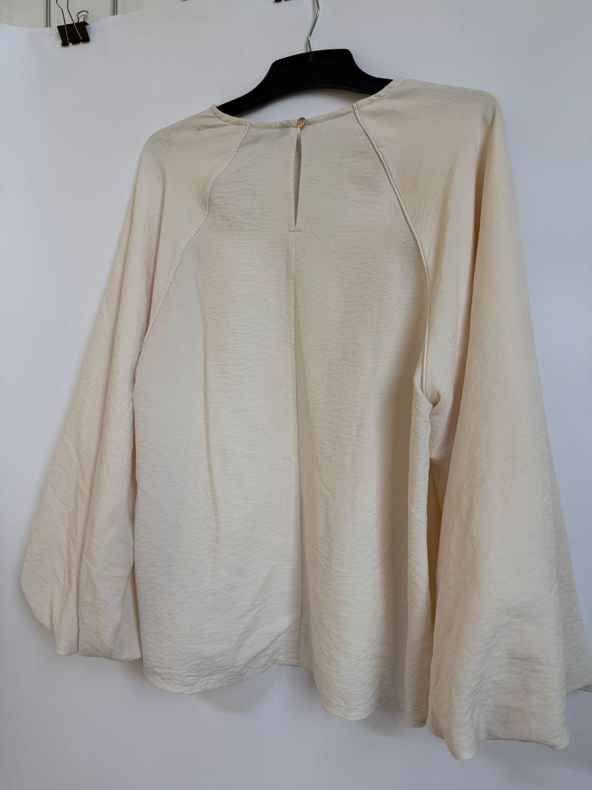 a white shirt hanging on a white wall