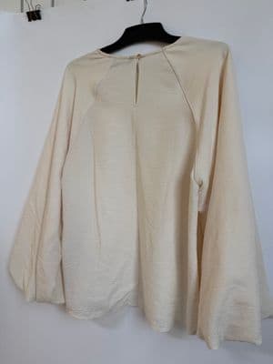 a white shirt hanging on a white wall