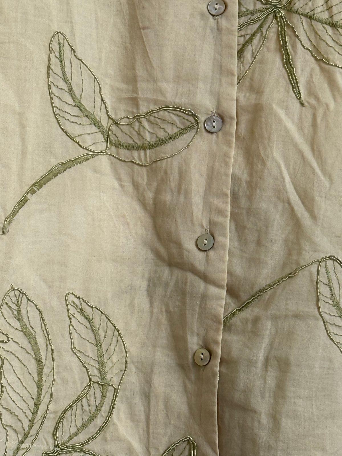 a close up of a shirt with leaves on it