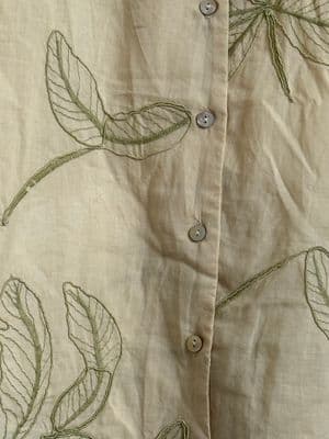 a close up of a shirt with leaves on it