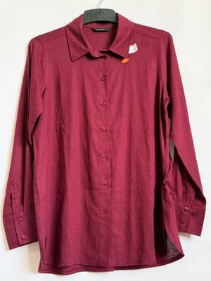 a red shirt hanging on a white wall