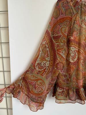a scarf hanging on a wall next to a tiled wall