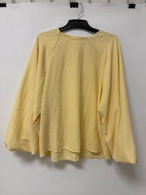 a yellow top hanging on a white wall
