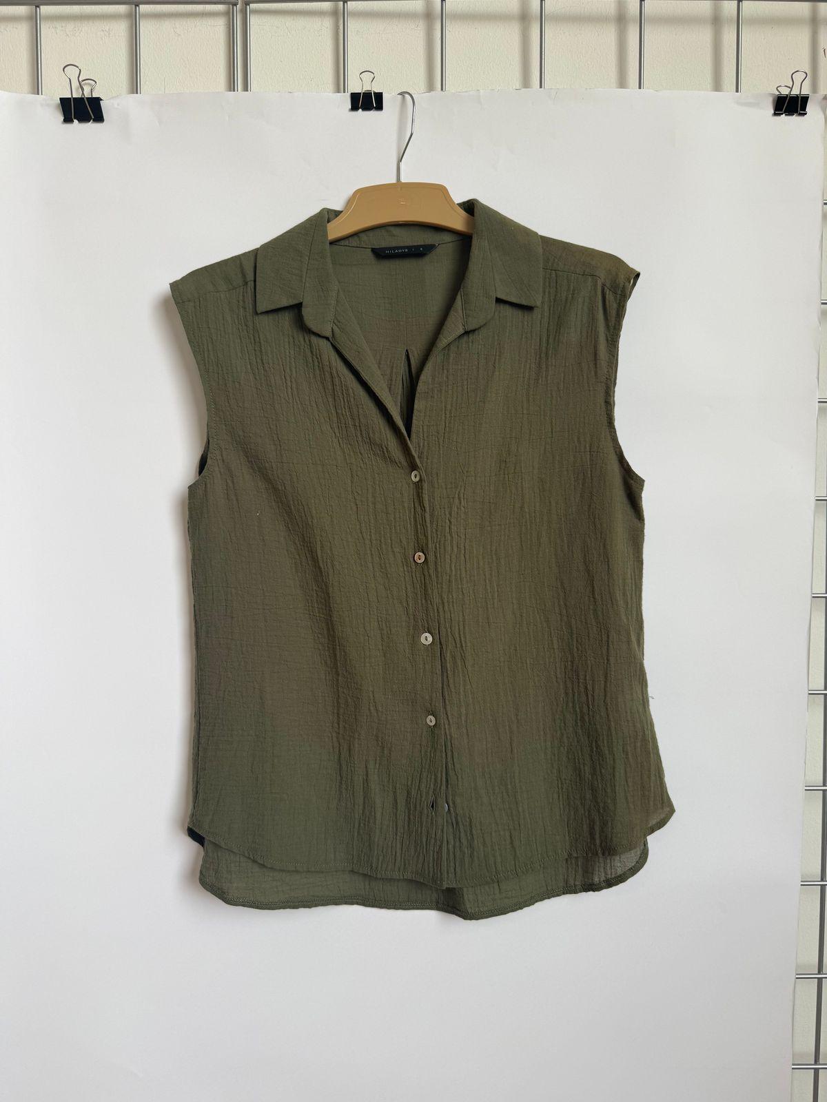 a green shirt hanging on a white wall