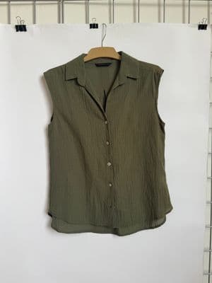 a green shirt hanging on a white wall
