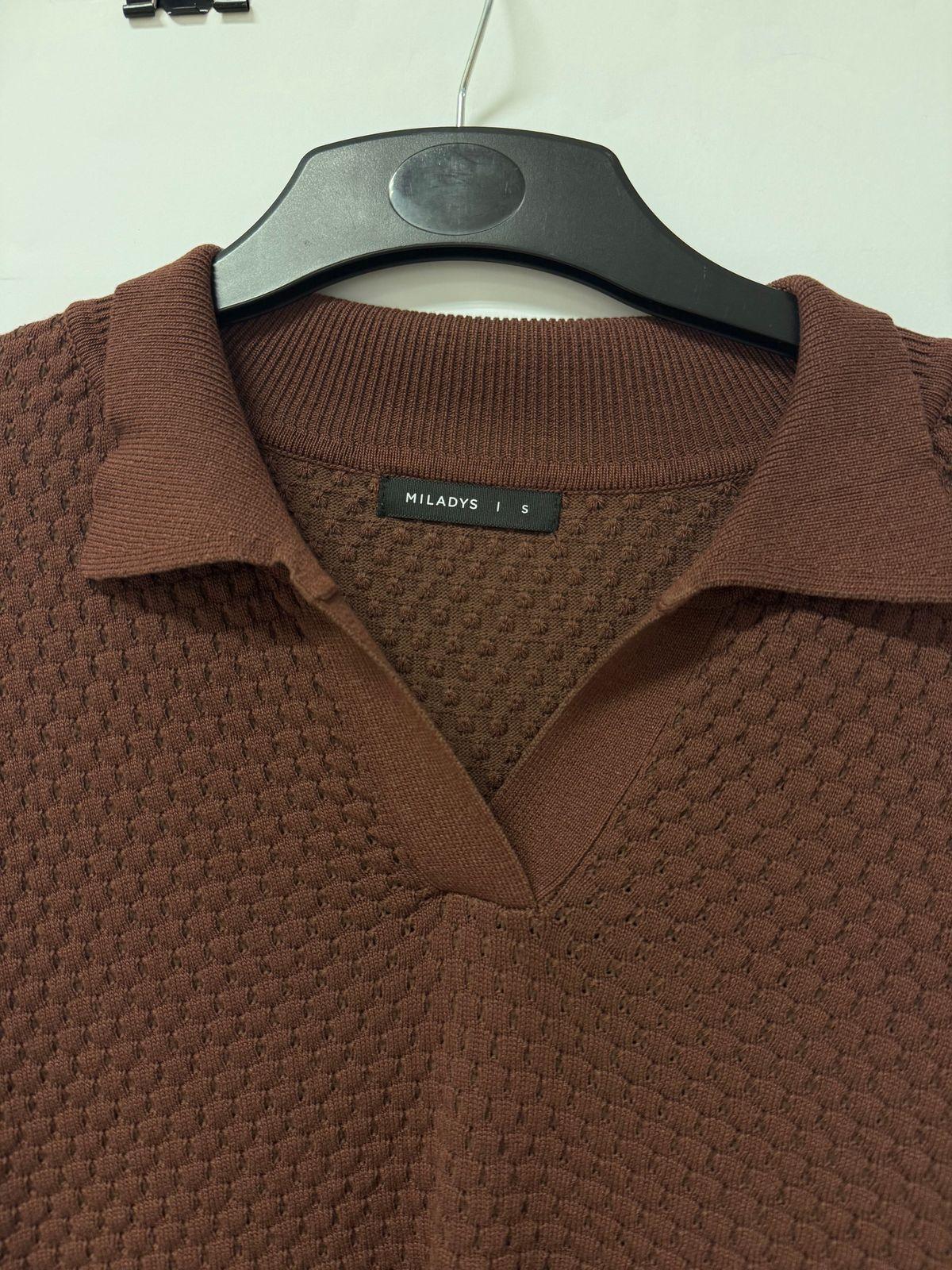 a brown polo shirt hanging on a hanger