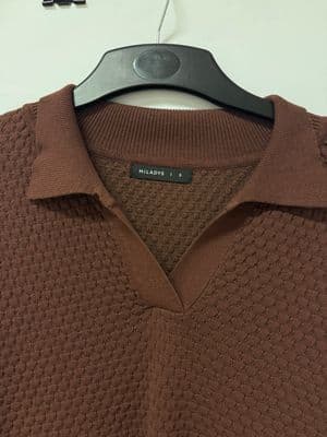 a brown polo shirt hanging on a hanger