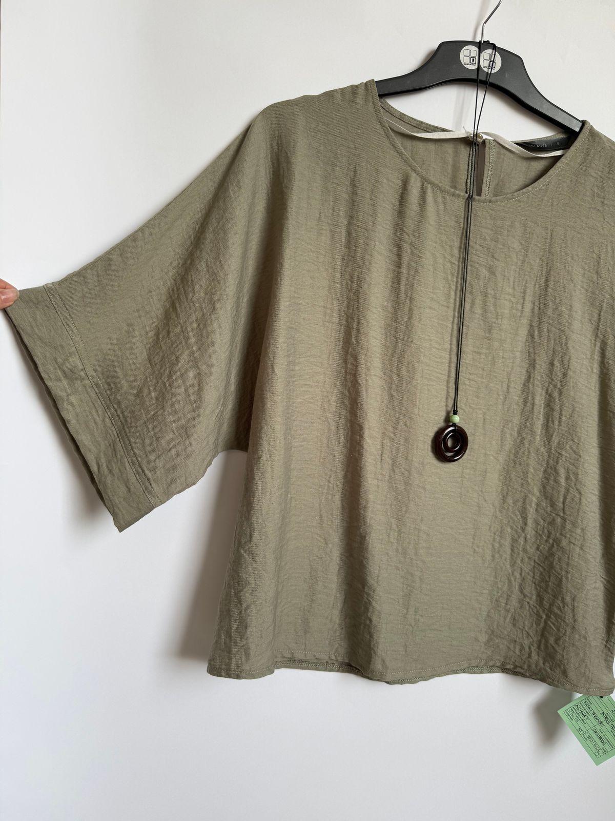 a shirt hanging on a hanger on a wall