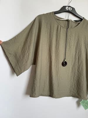 a shirt hanging on a hanger on a wall
