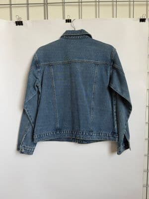 a denim jacket hanging on a wall