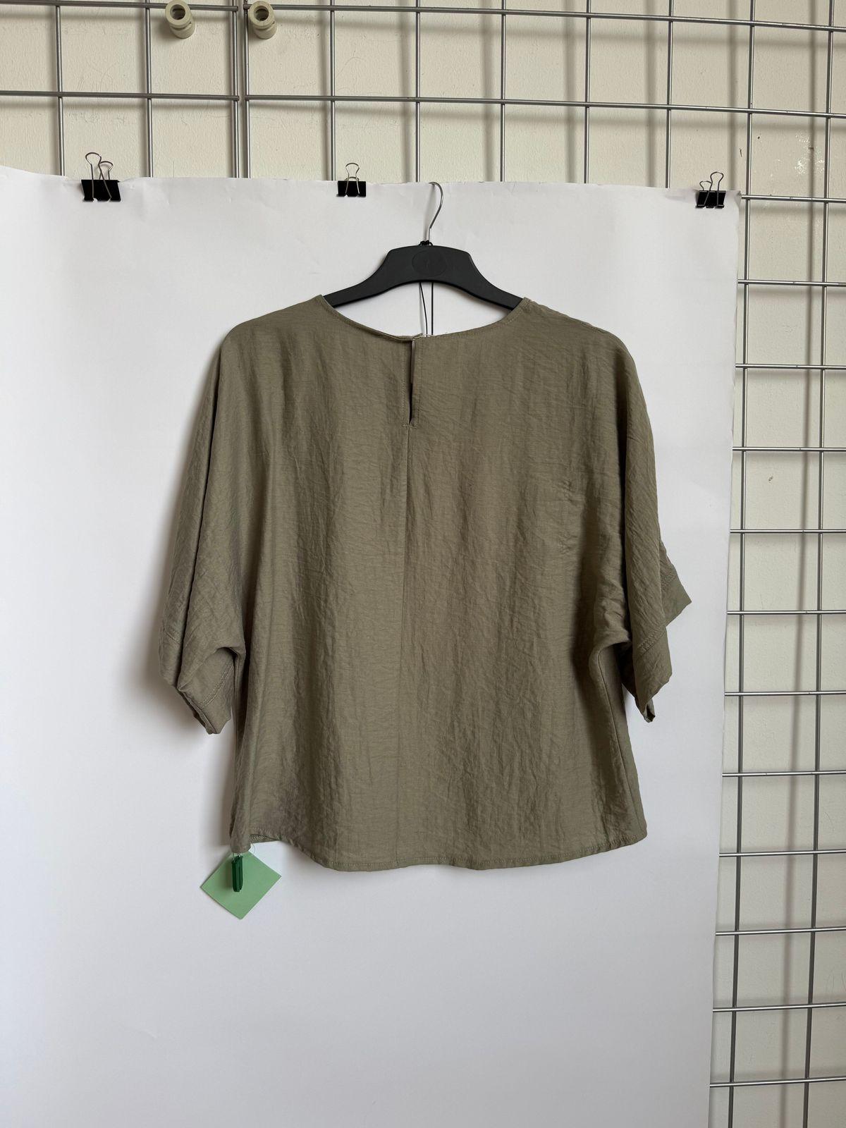 a green shirt hanging on a white wall