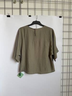 a green shirt hanging on a white wall
