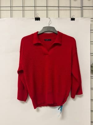 a red sweater hanging on a white wall
