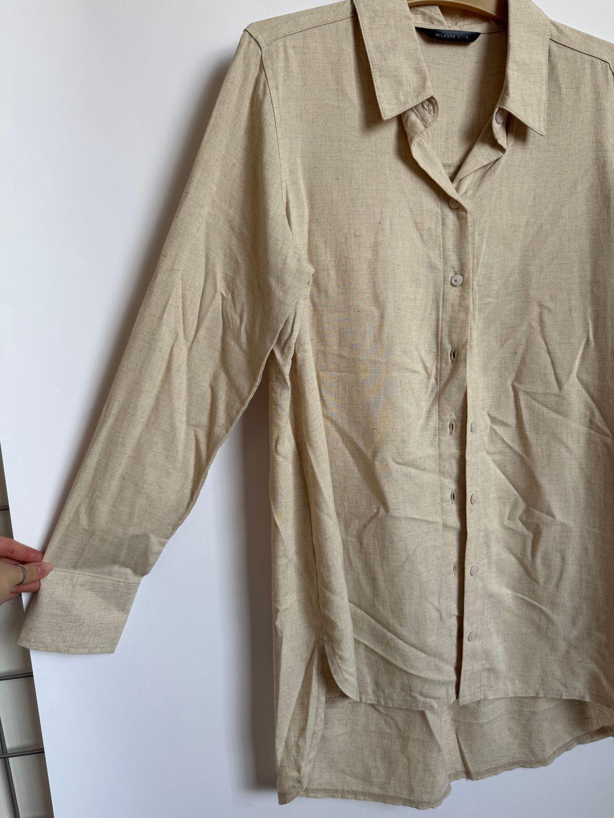 a shirt hanging on a clothes rack next to a ladder