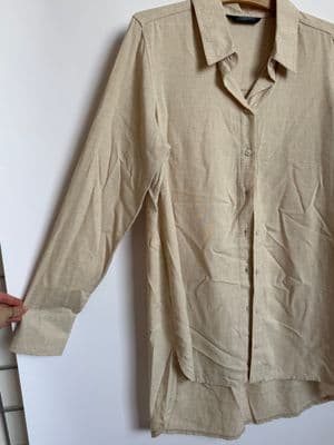 a shirt hanging on a clothes rack next to a ladder