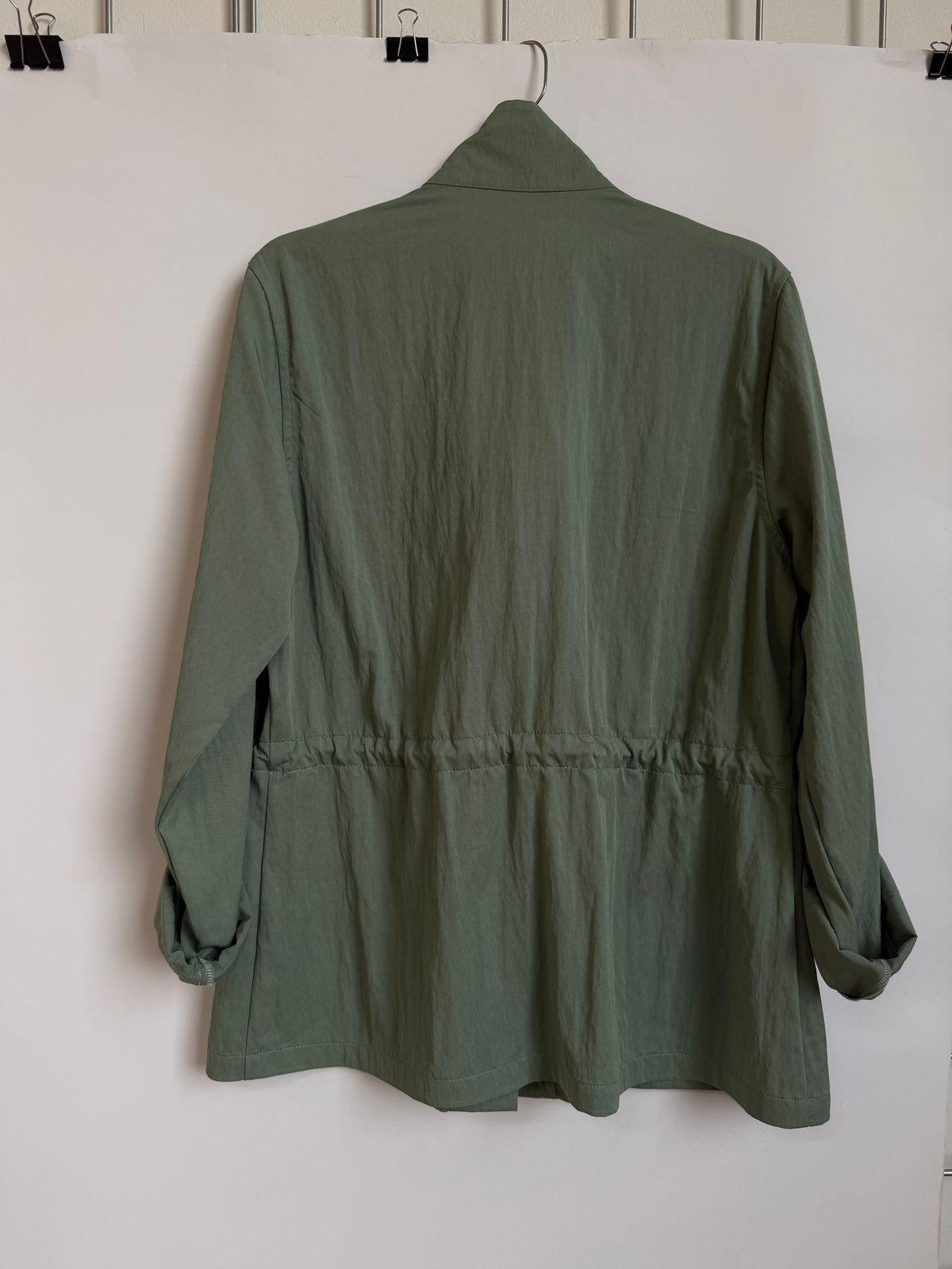 a green jacket hanging on a white wall