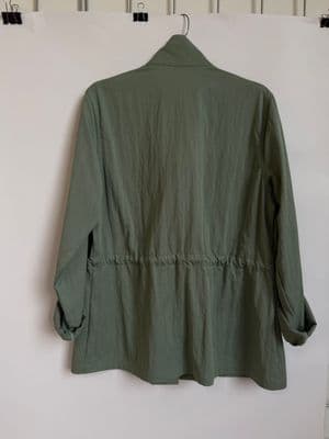a green jacket hanging on a white wall