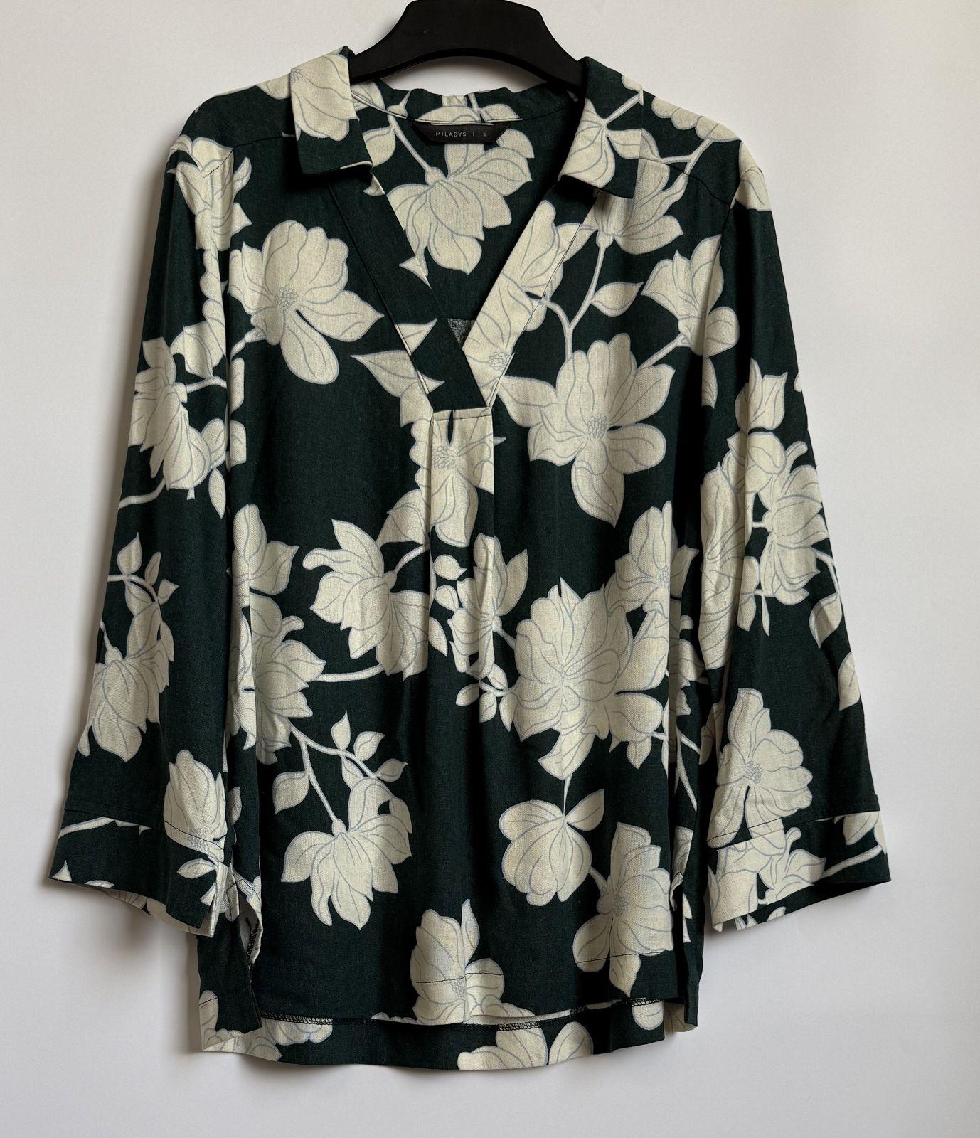 a black and white floral shirt hanging on a wall