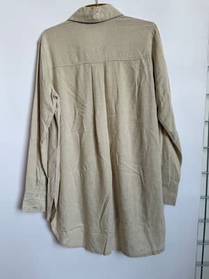 a beige shirt hanging on a white wall