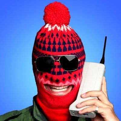 a man wearing a red and blue knitted hat while holding a cell phone