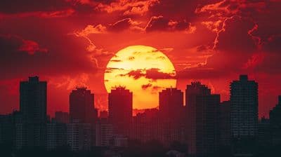 the sun is setting over a city with tall buildings